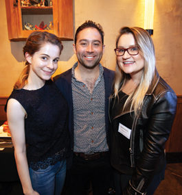Two women and a man pose at the San Francisco holiday party